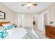 Bright bedroom with a ceiling fan, white bedding, and doorways to a closet and bathroom at 2958 N Xenia St, Denver, CO 80238