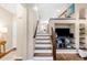 Bright entryway featuring hardwood floors, a staircase with white risers and a custom built-in media center at 2958 N Xenia St, Denver, CO 80238