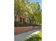 Street view of brick townhomes with arched doorways, complemented by lush green trees and lawn at 2958 N Xenia St, Denver, CO 80238