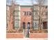 Charming red brick townhome featuring arched doorways and bay windows, creating a welcoming facade at 2958 N Xenia St, Denver, CO 80238