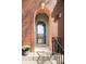 Close-up of arched brick doorway with glass front door, potted flowers, and modern exterior lighting at 2958 N Xenia St, Denver, CO 80238