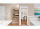 Hallway showcasing an open half bathroom next to a staircase with white walls and wood flooring at 2958 N Xenia St, Denver, CO 80238