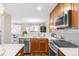 Well-lit kitchen featuring white countertops, stainless steel appliances, wood cabinets, and a modern backsplash at 2958 N Xenia St, Denver, CO 80238