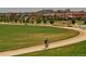 Scenic neighborhood view featuring homes, green spaces, and a cyclist enjoying a peaceful ride along a winding path at 2958 N Xenia St, Denver, CO 80238