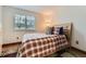 Cozy bedroom with a plaid bedspread, natural light, and hardwood floors at 5404 W Canyon Trl # C, Littleton, CO 80128