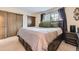 Comfortable main bedroom featuring a bed with green pillows, closets, large windows, and soft carpet flooring at 5404 W Canyon Trl # C, Littleton, CO 80128