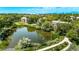 Aerial view of a pond surrounded by greenery and walking path between apartments and townhomes at 12156 Melody Dr # 201, Westminster, CO 80234