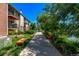 Apartment building with balconies and landscaped walkway with benches, creating a serene outdoor space at 12156 Melody Dr # 201, Westminster, CO 80234