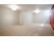 Spacious basement with neutral carpet, white walls, door and ceiling lights at 1578 S Syracuse St, Denver, CO 80231