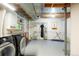 Basement laundry area with modern washer and dryer, shelving, and an ironing board at 1578 S Syracuse St, Denver, CO 80231
