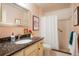 Bathroom featuring a shower, toilet, vanity, large mirror, and granite countertops at 1578 S Syracuse St, Denver, CO 80231