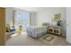 Light-filled bedroom with large window, a single bed with charming floral accents, and a cozy rug at 1578 S Syracuse St, Denver, CO 80231