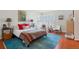 Sunlit bedroom featuring wood floors, shuttered windows, a bed with colorful pillows, and sitting area at 1578 S Syracuse St, Denver, CO 80231