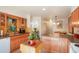 A kitchen featuring wood cabinets, a tile backsplash with colorful art, and stainless steel appliances at 1578 S Syracuse St, Denver, CO 80231