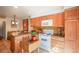 Traditional kitchen with wood cabinets, yellow backsplash, white appliances, and tile flooring at 1578 S Syracuse St, Denver, CO 80231