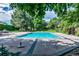 Sparkling community pool surrounded by mature trees and lounge area at 1578 S Syracuse St, Denver, CO 80231