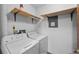 Functional laundry room with washer, dryer, and shelving for storage at 1074 S Dearborn St # 103, Aurora, CO 80012