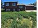Back exterior view of two-story home with lush greenery and a detached garage at 275 Mckinley Dr, Bennett, CO 80102