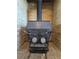 Close-up of a vintage Schrader wood-burning fireplace with detailed brickwork and unique vintage hardware at 275 Mckinley Dr, Bennett, CO 80102