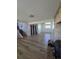 View of the spacious living room featuring modern flooring and stairs to the left, leading to the upper level at 275 Mckinley Dr, Bennett, CO 80102