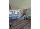 Open-concept living area featuring hardwood floors, a stylish gray accent wall, and seamless connection to the kitchen at 275 Mckinley Dr, Bennett, CO 80102