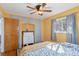 Bedroom with a ceiling fan, built in wardrobe, and a window with blue curtains at 4040 Ames St, Wheat Ridge, CO 80212