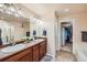 Bathroom with double sink vanity, open closet, shower, and bath at 6916 Crestop Pl # F, Parker, CO 80138