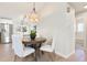 Open-concept kitchen and dining area with modern decor, hardwood floors, and access to the bathroom at 12050 Dahlia Dr, Thornton, CO 80241