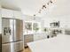 Bright kitchen features stainless steel appliances, white cabinets, marble backsplash, and quartz countertops at 12050 Dahlia Dr, Thornton, CO 80241