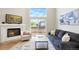 Cozy living room with a fireplace, large windows, and a sliding glass door to the deck at 12050 Dahlia Dr, Thornton, CO 80241