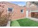 Quaint backyard featuring lush artificial grass, a privacy fence and charming string lights overhead at 2427 W Argyle Pl, Denver, CO 80211