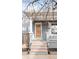 Inviting front porch with updated wooden steps leading to a gray painted facade, blending classic style with modern updates at 2427 W Argyle Pl, Denver, CO 80211