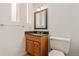 Small bathroom features a black granite countertop, wood vanity, and a white toilet at 6407 S Heritage W Pl, Centennial, CO 80111