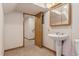 Half bath with pedestal sink and tile flooring; access to unfinished basement at 6407 S Heritage W Pl, Centennial, CO 80111