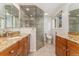 Updated bathroom featuring double sinks, a walk-in shower with beautiful tile, and a separate toilet area for added privacy at 6407 S Heritage W Pl, Centennial, CO 80111