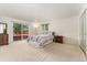Bright bedroom features a sliding door to a wooden deck, a neutral carpet, and a closet for optimal storage at 6407 S Heritage W Pl, Centennial, CO 80111