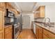 Well-lit kitchen with stainless steel appliances, wood cabinets, and hardwood floors at 6407 S Heritage W Pl, Centennial, CO 80111