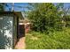 Backyard with small storage shed, brick walkway, and overgrown grass offers potential for customization at 1195 Boston St, Aurora, CO 80010