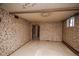 Spacious basement with patterned wallpaper and view to storage room at 1195 Boston St, Aurora, CO 80010