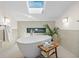 Bright bathroom featuring a skylight, a soaking tub, and a decorative fireplace at 11241 E Cimmarron Dr, Englewood, CO 80111