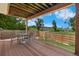 Relaxing covered deck with wood-style flooring and seating overlooking the landscaped backyard at 11241 E Cimmarron Dr, Englewood, CO 80111