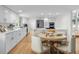 Modern kitchen featuring white cabinets, stainless steel appliances, a center island, and a round wooden table at 11241 E Cimmarron Dr, Englewood, CO 80111