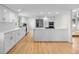 Sleek kitchen with white cabinets, stainless steel appliances, hardwood floors and a large center island at 11241 E Cimmarron Dr, Englewood, CO 80111