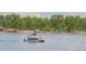 Lakeside scene with a pontoon boat on the water and a crowded beach in the background, perfect for summer fun at 11241 E Cimmarron Dr, Englewood, CO 80111