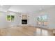 Bright living room with a corner fireplace, hardwood floors, and French doors leading to the outdoors at 11241 E Cimmarron Dr, Englewood, CO 80111
