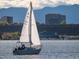 A sailboat sailing on the clear water with a mountainous background, highlighting recreational opportunities nearby at 11241 E Cimmarron Dr, Englewood, CO 80111