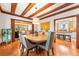 Dining room with hardwood floors, wood ceiling beams, and view of kitchen and living room at 562 N Gilpin St, Denver, CO 80218