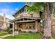 Attractive two-story home with brick facade, covered porch, and lush front yard at 562 N Gilpin St, Denver, CO 80218