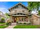 Charming two-story home with brick facade, covered porch, and well-manicured front yard at 562 N Gilpin St, Denver, CO 80218