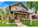 Inviting two-story home with brick facade, covered porch, and manicured front yard at 562 N Gilpin St, Denver, CO 80218
